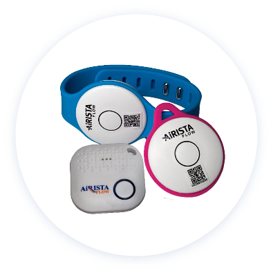 Assorted AiRISTA Flow wearable patient tracking devices including a blue wristband, a pink tag, and a white sensor, demonstrating advanced Real-Time Location Systems (RTLS) technology for enhanced healthcare monitoring and operational efficiency.